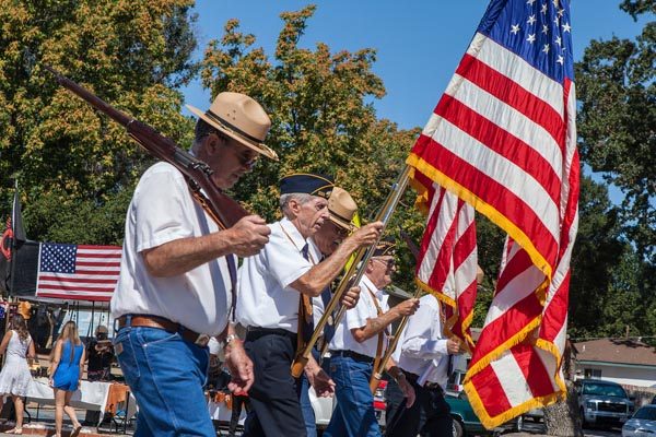 The parade began with spectators rising and removing their hats as the North County Veterans Color Guard and Honor Guard marched by with the flag. Photo by Rick Evans. 