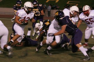 Paso High's Nathaniel Harris gets some assistance from the Bearcats offensive line as runs the ball past a slew of Warriors on Friday night. Photo courtesy of Jennifer Railsback.