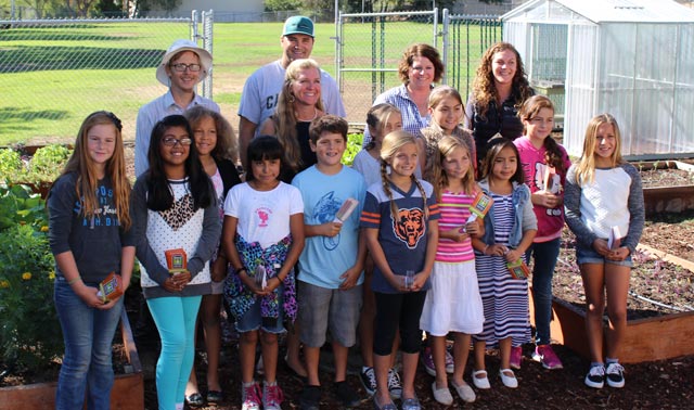 This photo of SAVOR garden donation includes (back row, left to right) Greg Ellis (One Cool Earth), Gregg Wangard (Cliffs Resort/Boutique Hotel Collection), Ellalina Keller (principal of Georgia Brown Elementary), Stacie Jacob (CEO, Visit SLO County), Victoria Carranza (One Cool Earth), plus the students of Georgia Brown Elementary who volunteer in the school garden.  