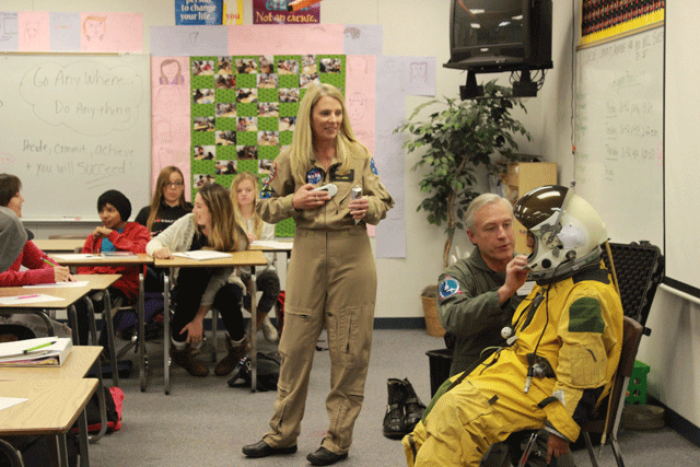 Paso Robles High School algebra teacher Bobbie Mitchell, standing, talks about the space suit that her husband, Doug, helps freshman Erika Rendon get into. Photo by Heather Young