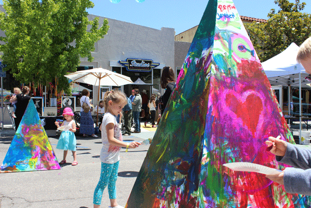 Children and adults colloborated in painting large pyramids on Pine Street in front of Studios on the Park on Saturday. Photo by Heather Young
