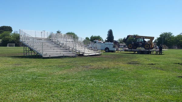 Once dropped off, a tractor was unloaded that moved the bleachers into place. Photo by Skye Ravy.