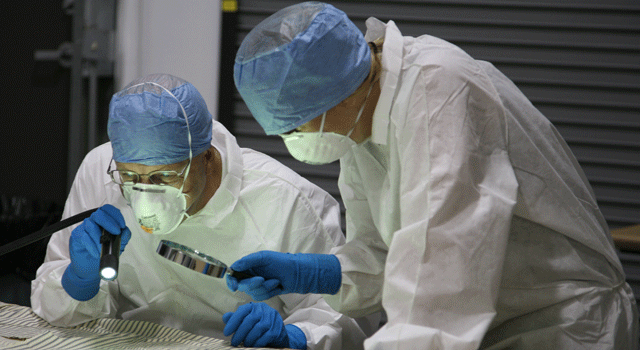 Two forensic specialists examine evidence in San Luis Obispo County Sheriff's crime lab.