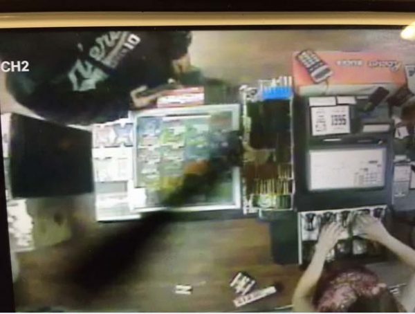 Partial photo of suspect showing sweatshirt and handgun. 