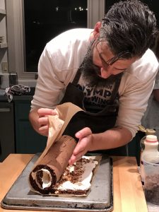 Chef Veatch expertly rolling the cream-filled sponge cake into a log shape
