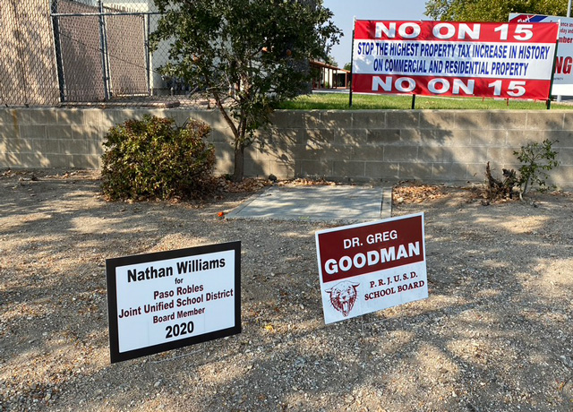 Signs for school board candidates Nathan Williams and Greg Goodman, and a "No on 15" sign at the corner of Spring Street and First Street.
