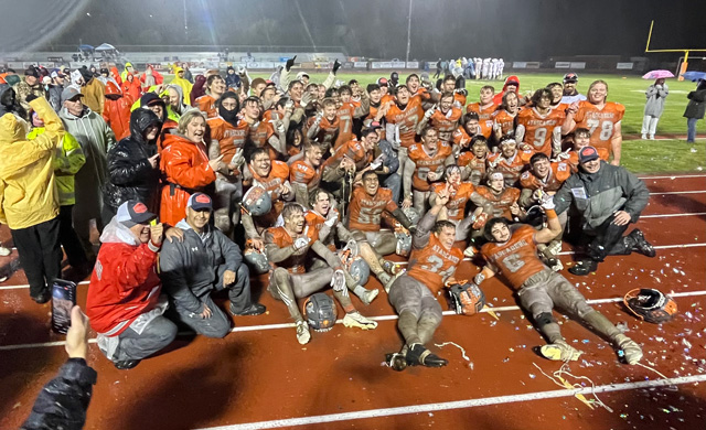 Atascadero Greyhounds pose for a victory photo after the muddy game.