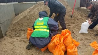 CERT team member helps fill sandbags