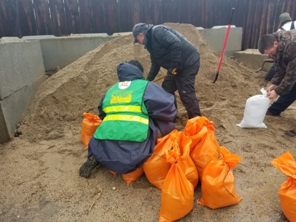 CERT team member helps fill sandbags